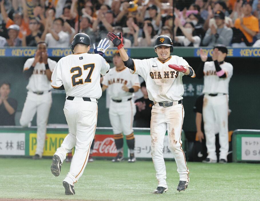 ７回、巨人・長野の一ゴロが野選を誘い、タッチを交わして喜ぶ生還した岸田と増田大