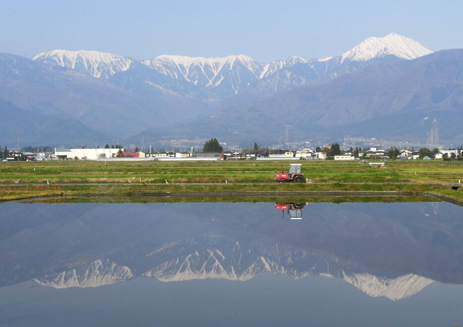 常念岳（右）など北アルプスの山々と麓に水田が広がる安曇野市の風景＝2024年6月撮影