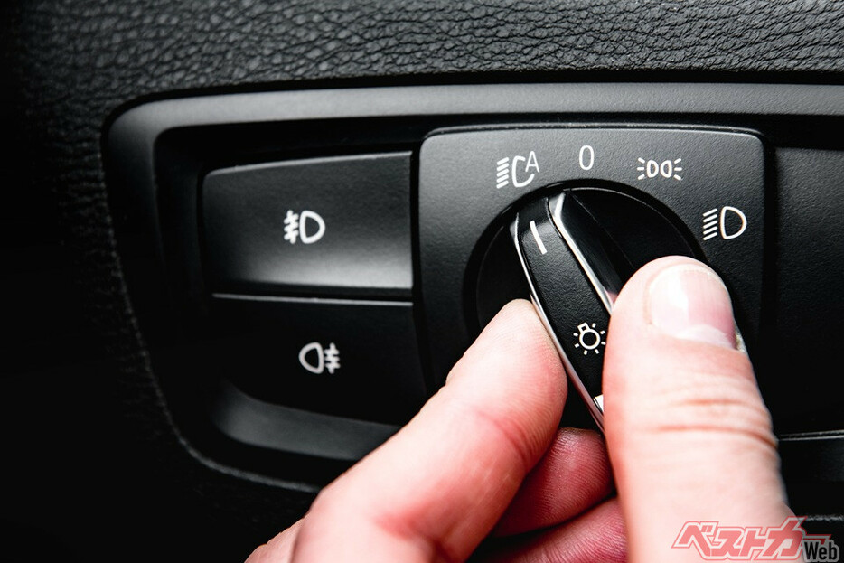 Hand turning auto light in luxury car.