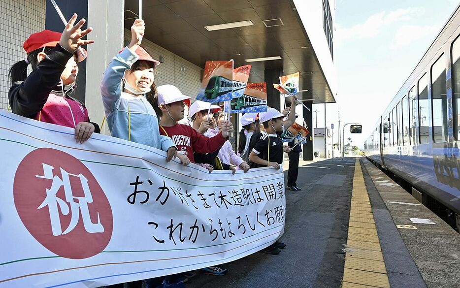 横断幕を手に、到着した「リゾートしらかみ」を歓迎する子どもたち