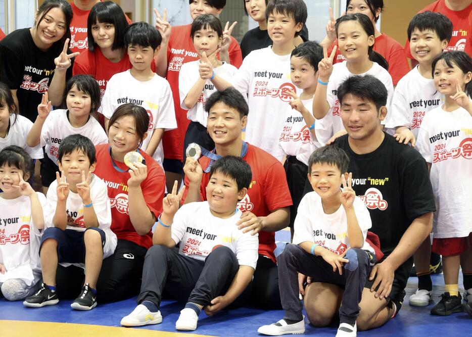 スポーツの日のイベントで子どもたちと写真に納まるレスリング女子の元木咲良（前列左から3人目）ら＝14日、東京都内