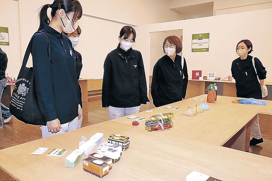 デザインを鑑賞する来場者＝富山市民プラザ