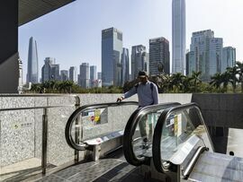 A pedestrian passes the Shenzhen Stock Exchange building in Shenzhen, China. Photographer:  /Bloomberg