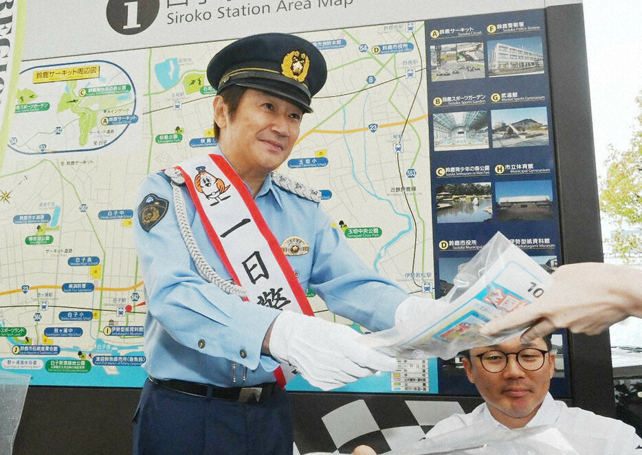 白子駅前で交通安全など啓発資料を配る近藤真彦さん＝三重県鈴鹿市白子駅前で２０２４年１０月１５日午後４時４分、渋谷雅也撮影