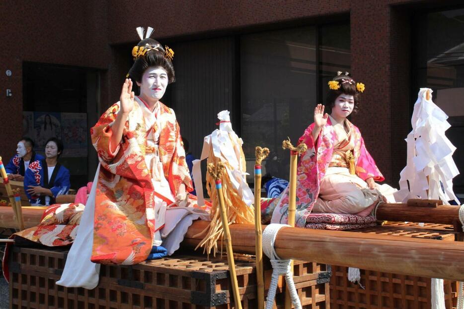 見物客らに手を振りながら神社へ向かう花嫁役＝神河町寺前