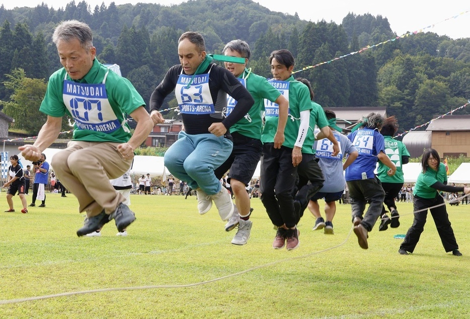 運動会で大縄跳びをする参加者