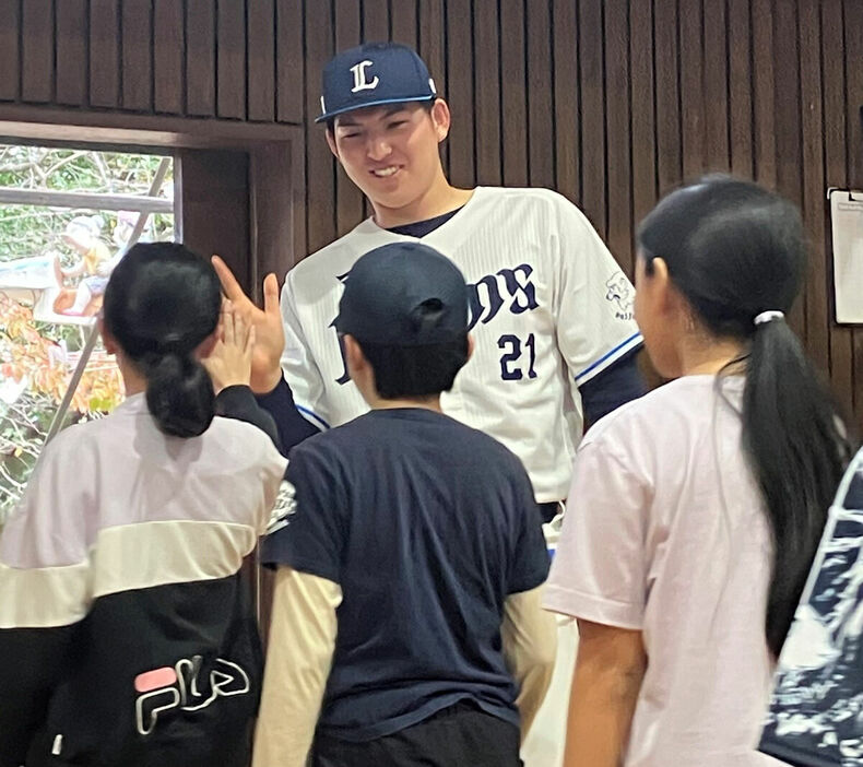 児童とハイタッチをかわす西武・武内夏暉投手