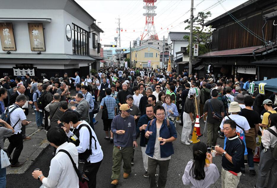 歩行者天国となった国道20号の道路いっぱいになってはしご酒を楽しむ人たち