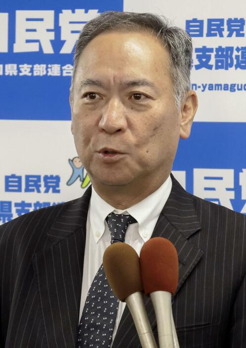 記者団の取材に応じる自民党山口県連の友田有幹事長＝28日、山口市