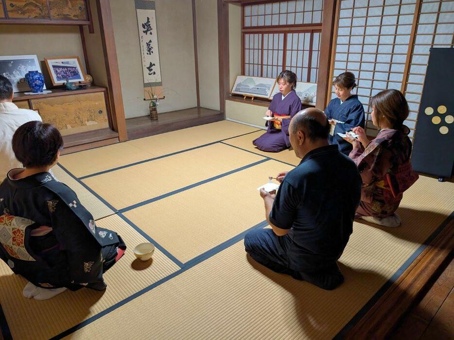 奥座敷で和菓子と抹茶を楽しむ参加者たち