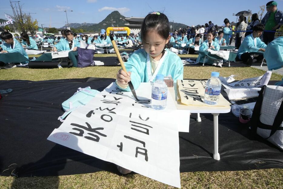 韓国の記念日「ハングルの日」のイベントで書道大会に参加する少女＝9日、ソウル（AP）