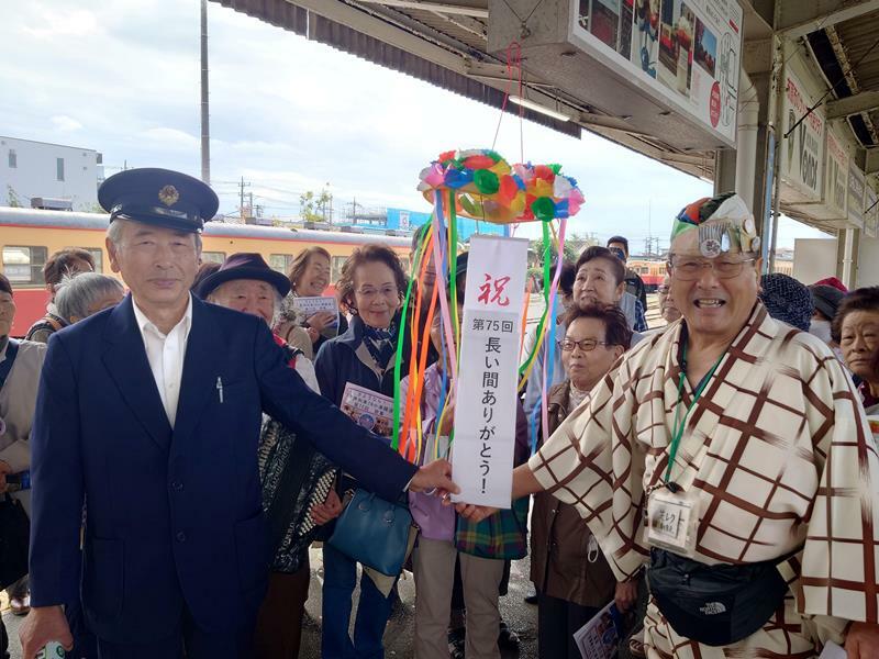 歌声列車運行終了の式典でくす玉を割った清水さん（右）＝20日、市原市の小湊鉄道五井駅