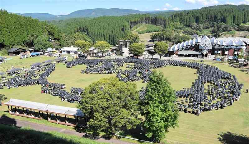 2024本の黒い雨傘で描いた柴三郎の地上絵。左側が首で右側が頭＝13日、小国町