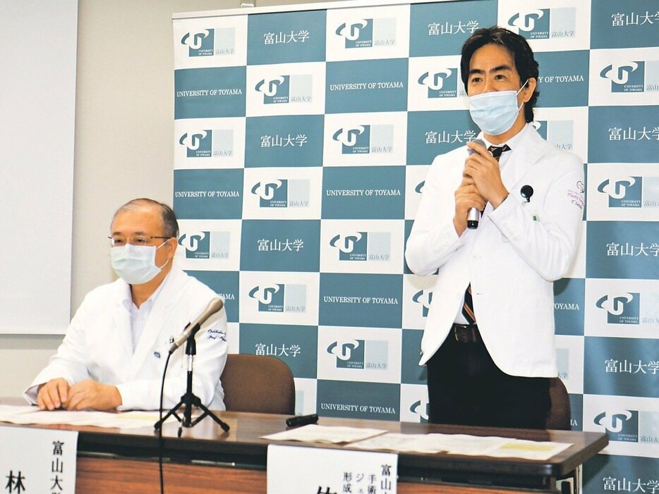 記者会見で治療の保険適用について説明する佐武センター長（右）と林院長＝富山大付属病院