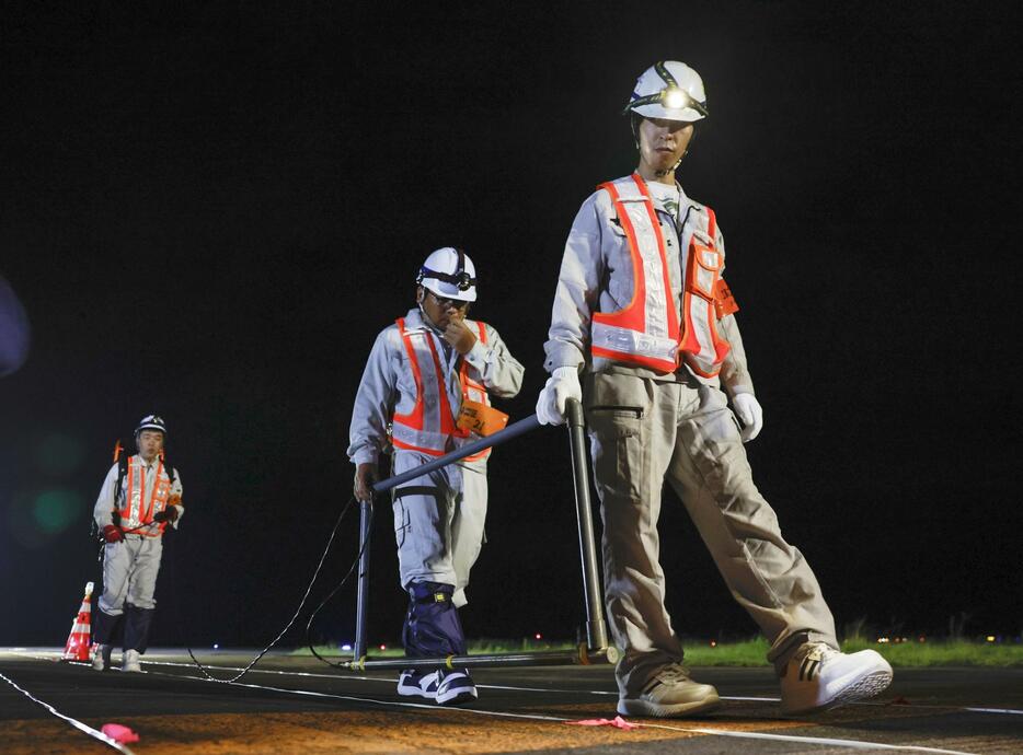 誘導路で不発弾が爆発した問題を受け、宮崎空港で「磁気探査」を行う作業員＝16日深夜