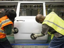 Employees scuff a door on the production line at a vehicle assembly plant in Arlington, Texas.