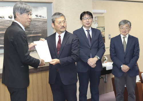 【中島議長（左）に意見書を手渡す小林会長（左から2人目）＝松阪市役所で】