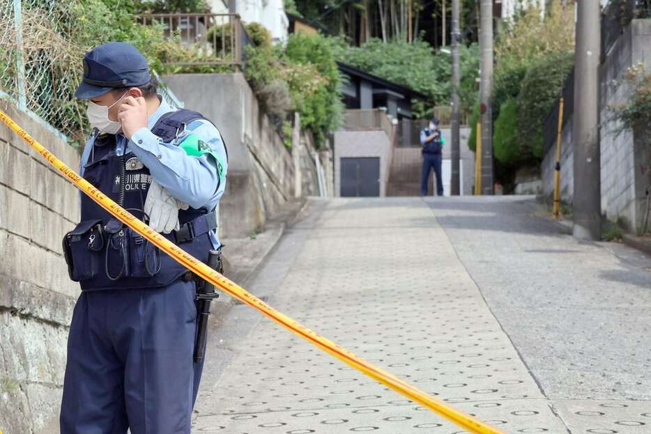 横浜市青葉区の強盗殺人事件の現場付近は規制線が張られ警察官が立っている