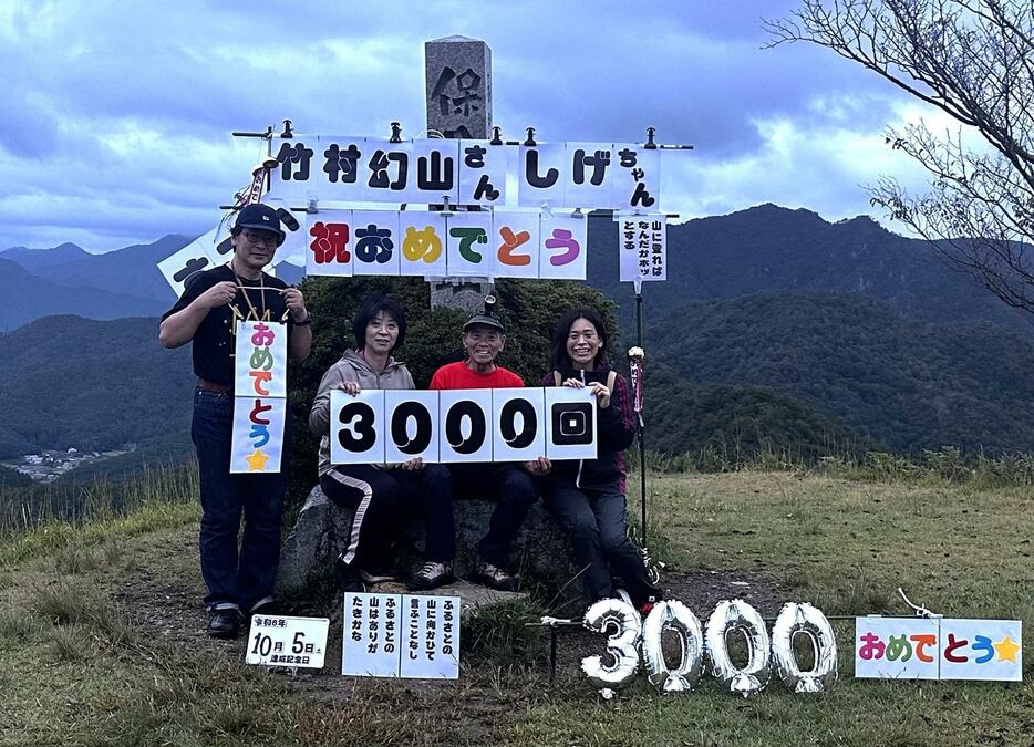 黒井城跡への登頂3000回達成を喜ぶ竹村さん（右から2人目）＝2024年10月5日午前5時55分、兵庫県丹波市春日町で