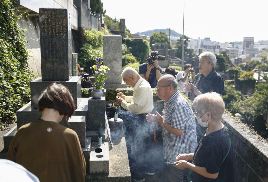 渡辺千恵子さんの墓前で手を合わせる長崎原爆被災者協議会のメンバーら＝12日午後、長崎市