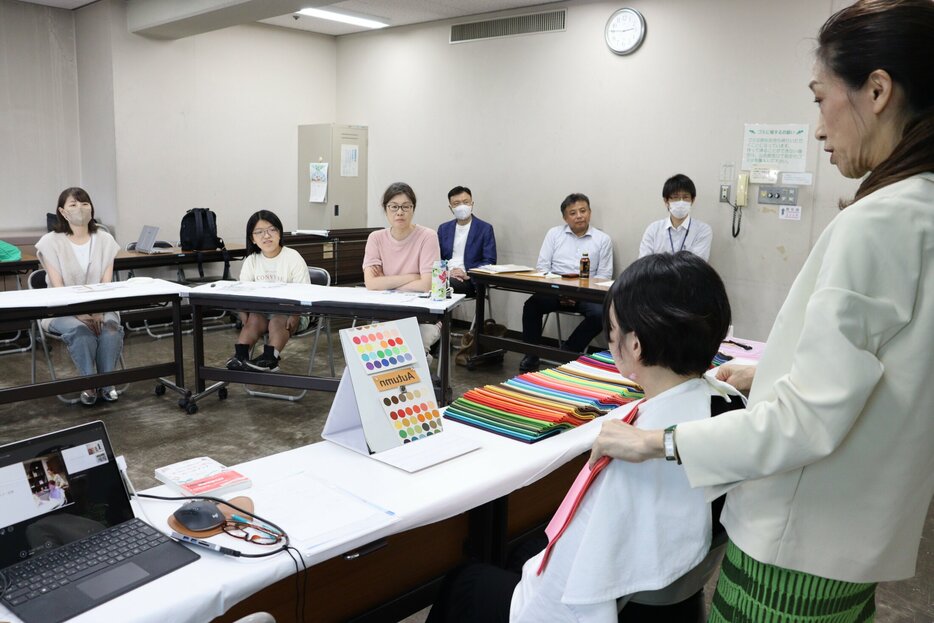 参加者の肌や瞳に調和する色を探す松本さん（右）＝長岡京市天神４丁目・中央公民館