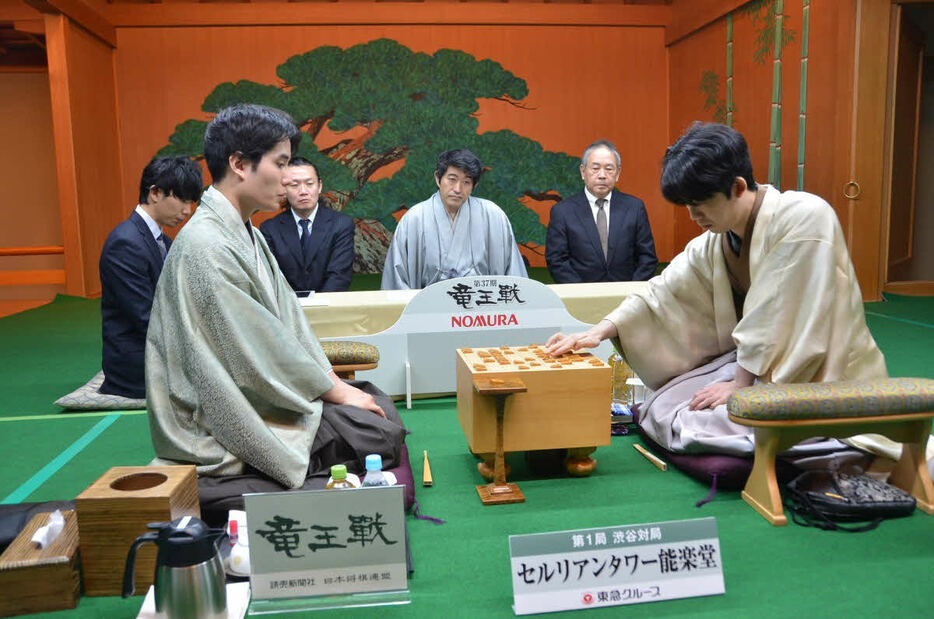 対局再開を前に初日の指し手を再現する先手の藤井聡太竜王（右）と後手の佐々木勇気八段（左、日本将棋連盟提供）