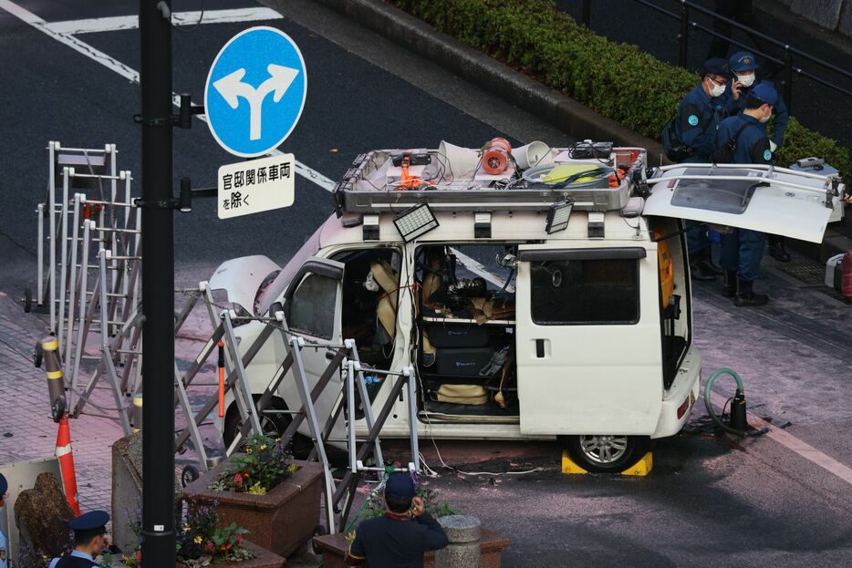 首相官邸前のバリケードに突っ込んだ車両。周囲には消防隊がまいたと思われる消火剤のような跡が広がっている ©時事通信