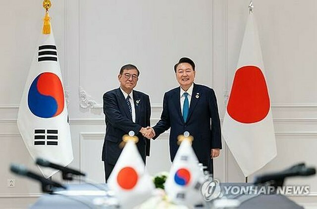 首脳会談で握手を交わす韓国の尹大統領（右）と日本の石破首相＝10日、ビエンチャン（聯合ニュース）