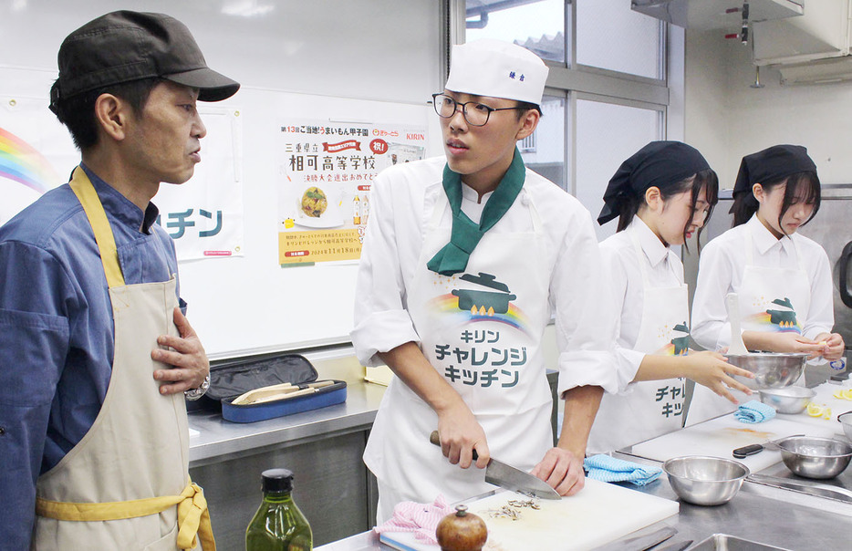 富澤さん（左）からアドバイスを受けて調理する（左2人目から）鎌倉君と西村さん、太田さん＝多気町相可の相可高で