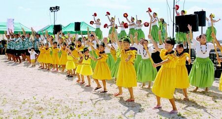 石垣島フラフェスティバルのオープニングでフラを踊る地元「メケアロハプメハナ」のメンバー＝１３日、石垣市の南ぬ浜ビーチ