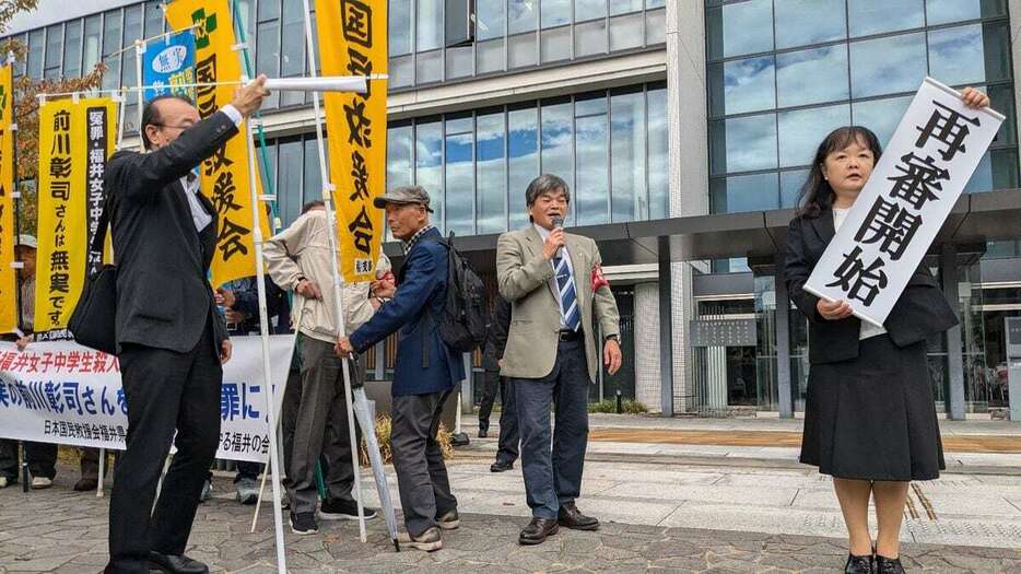 名古屋高裁金沢支部の決定を受けて、「再審開始」の旗を掲げる支援者ら＝23日、金沢市