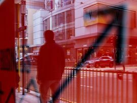 A pedestrian reflected in a sign in Hong Kong, China. Photographer: Paul Yeung/Bloomberg