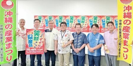 沖縄の産業まつりをＰＲした古波津昇会長（写真中央）ら実行委員会メンバー＝１７日、那覇市の沖縄産業支援センター