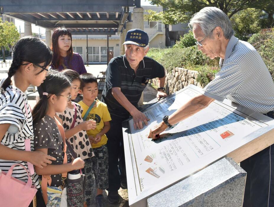 千歳公園の防災機能を説明する（右から）田村勝太郎さん、崔敏夫さん＝12日午後、神戸市須磨区千歳町２