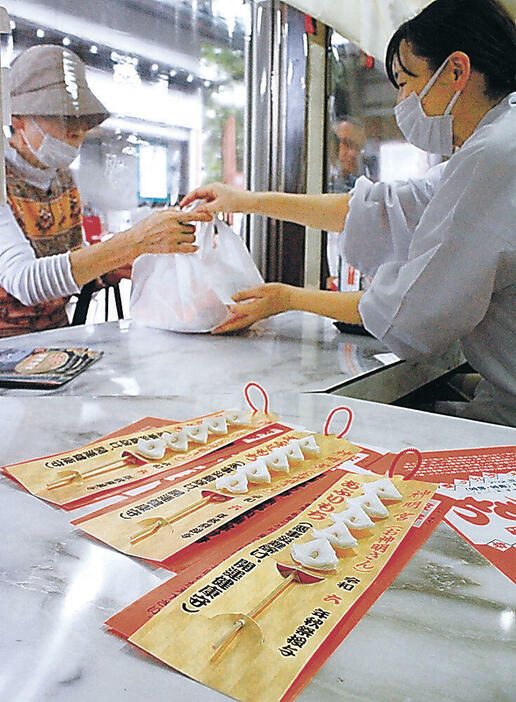 無病息災を願い、あぶりもちを買い求める参拝者=金沢市野町2丁目の神明宮