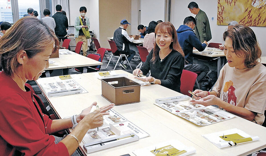 金箔貼り体験を楽しむツアー参加者＝金沢市森戸２丁目