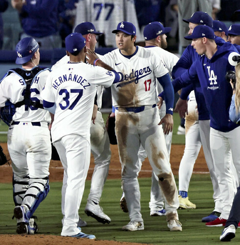 第１戦に勝利し喜ぶ大谷（中央）らドジャースの選手たち（１３日、米ロサンゼルスで）＝片岡航希撮影