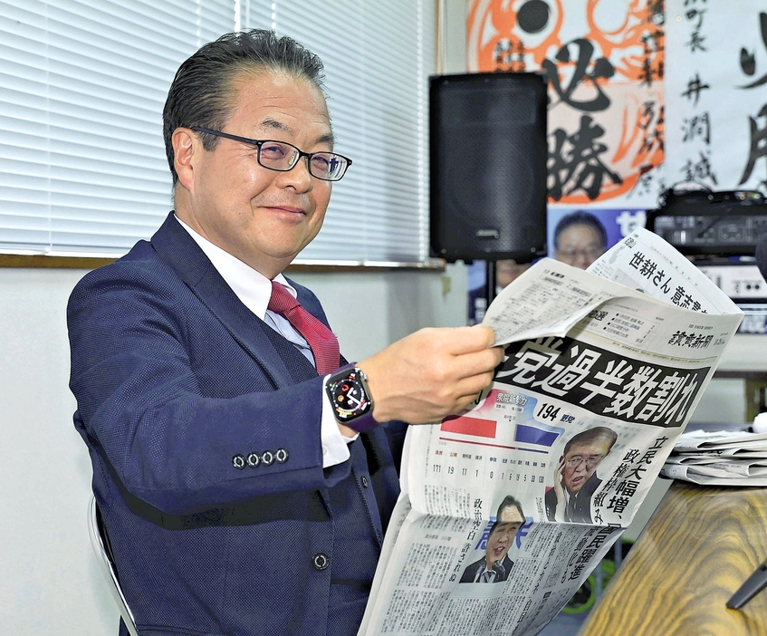 笑顔で新聞を読む世耕さん（和歌山県田辺市で）