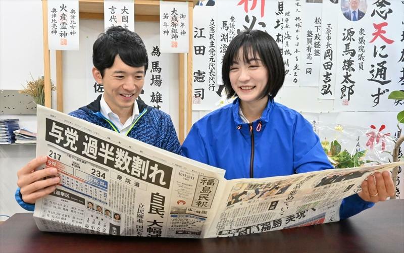 再選を報じる新聞に目を通す馬場さん（左）と妻菜里さん