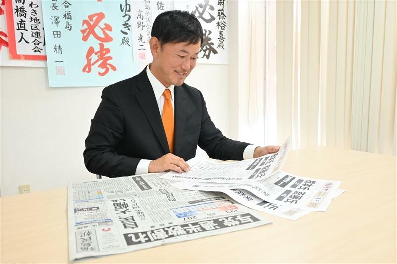 比例東北での復活当選を伝える号外や新聞に目を通す斎藤さん