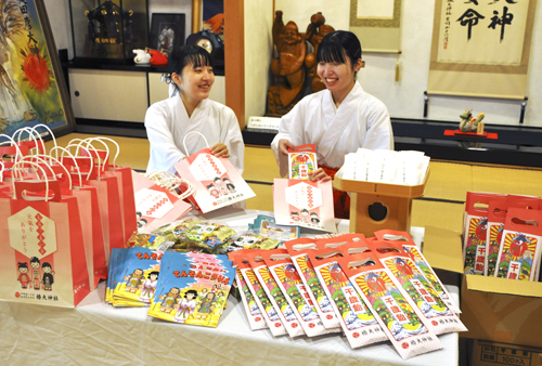 【祝い袋に千歳あめなどを詰めるみこら＝鈴鹿市山本町の椿大神社で】