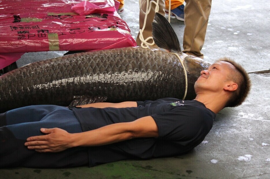 巨大な魚に添い寝する西山貴弘