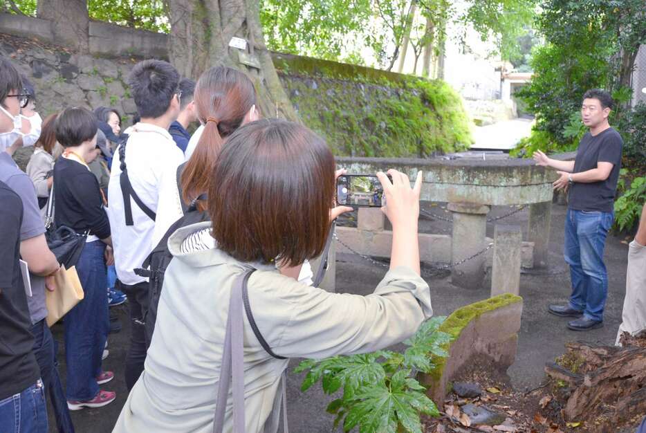 外国人富裕層向けのツアーに盛り込む観光地を興味深く視察する観光関係者ら＝１６日、鹿児島市黒神町の黒神埋没鳥居