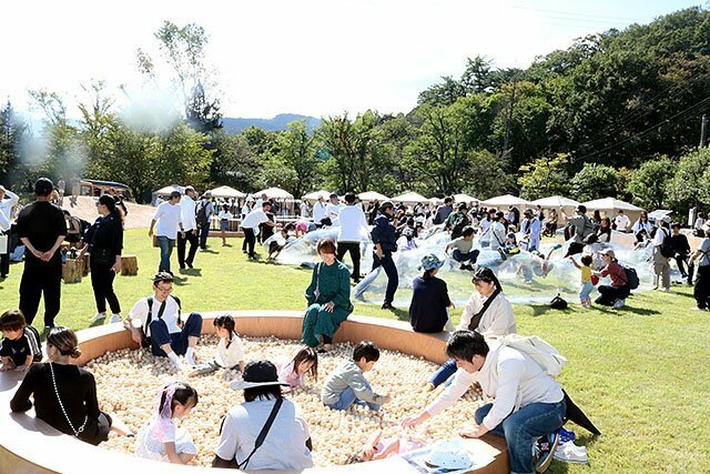 芝生広場に設けられた遊具で遊ぶ親子連れら＝南砺市の桜ケ池公園周辺