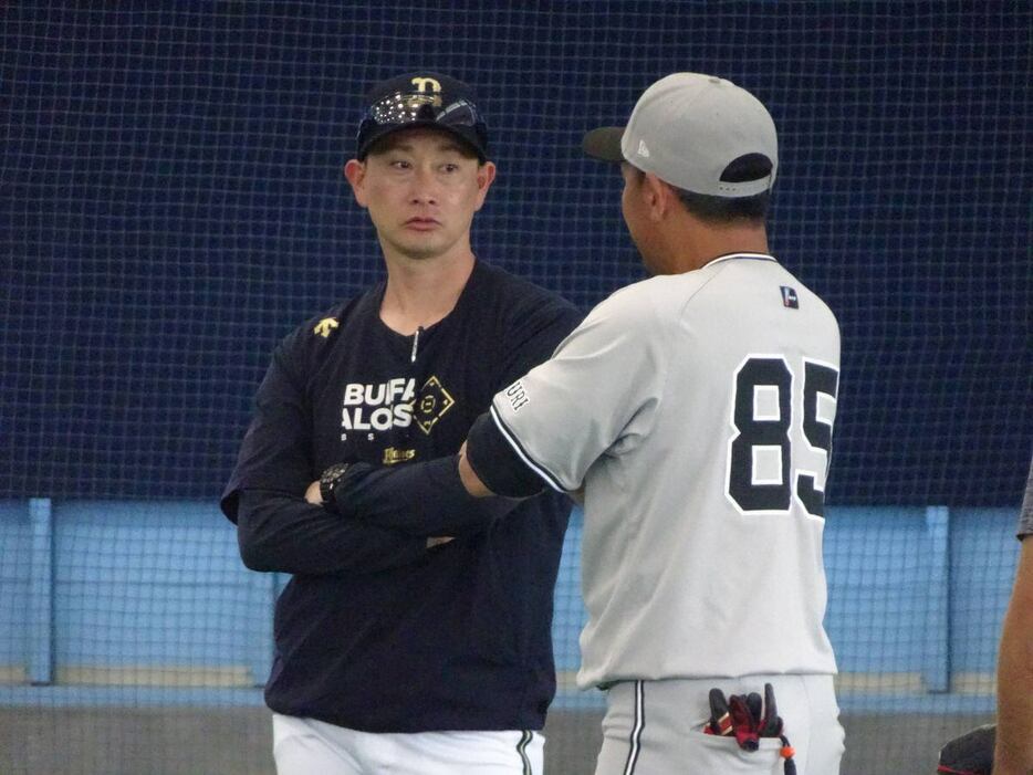 NTT西日本でチームメートだった巨人・脇谷亮太2軍内野守備コーチ（右）と談笑するオリックス・岸田護新監督＝宮崎市清武総合運動公園＝