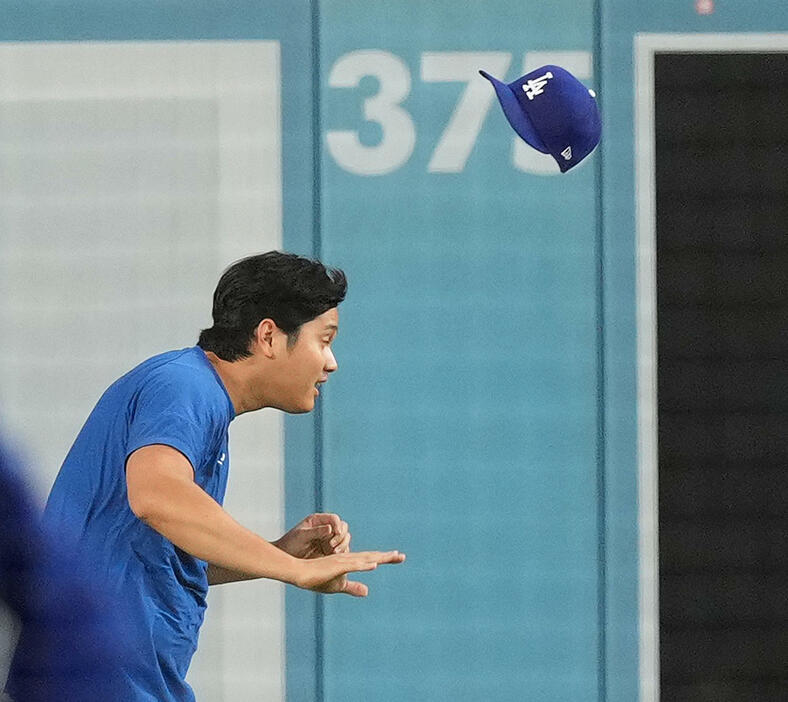 ワールドシリーズ前日、大谷はダッシュで落とした帽子を投げてもらうもあと少しのところで被れず（撮影・菅敏）