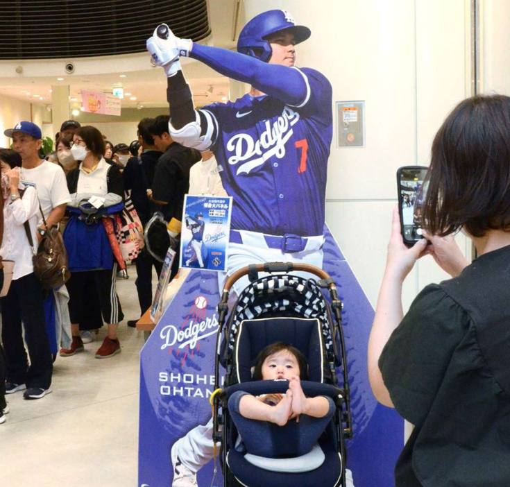 大谷翔平選手の等身大パネルと記念写真を撮る来場者＝４日、鹿児島市のアミュプラザ鹿児島