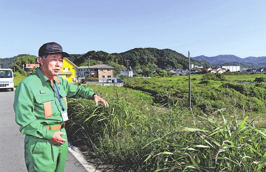 堤防が決壊した場所で水害を振り返る大広さん（兵庫県豊岡市で）