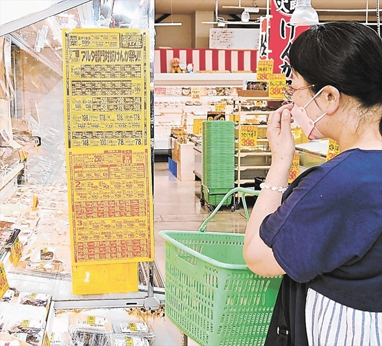 物価高の中、チラシで特売品を確認しながら買い物する来店者＝１日夕、福島市飯坂町・アルタ