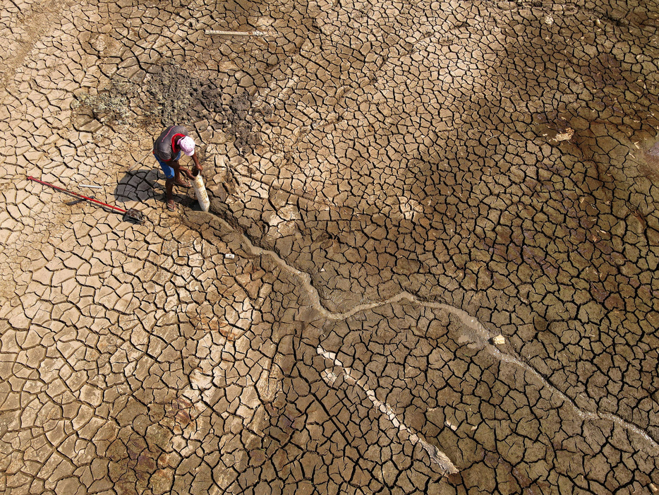 　１０月２８日、国連気候変動枠組条約（ＵＮＦＣＣＣ）事務局は、各国が提出済みの温暖化ガスの排出削減目標（ＮＤＣ）について、パリ協定の目標達成には依然、遠く及ばないとの年次報告書を公表した。写真は干上がったブラジルのプラケカラ湖で水を探す人。２０２３年１０月撮影（２０２４年　ロイター/Bruno Kelly）